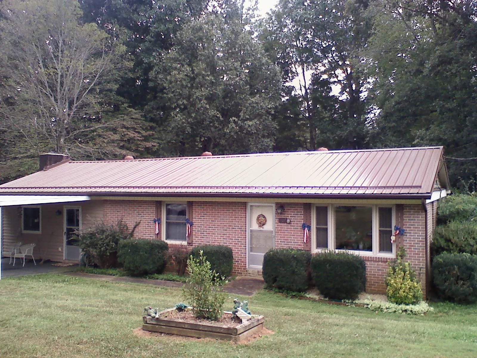 Bronze metal roof on a brick ranch home with a carport in West Wendover